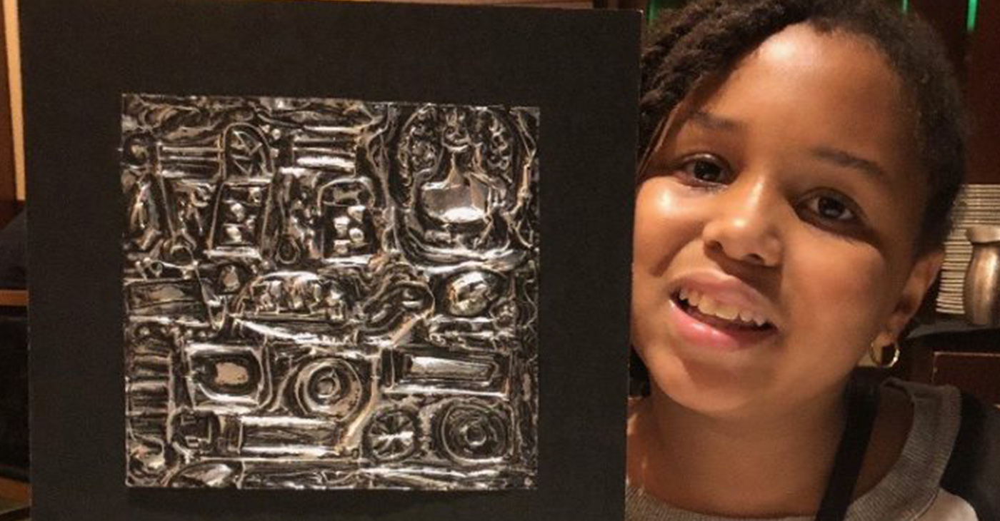 Zoe holding her first repousse piece created in MICA’s after school arts program, that she sold to Fogo de Chao manager. (Photo by Latease Lashley)