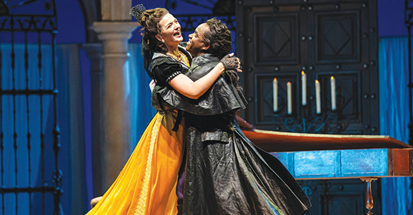 MARIANNE CREBASSA as Rosina and Lawrence Brownlee as Count Almaviva enjoy a victory hug during a scene from “The Barber of Seville” playing at Lyric Opera. (Photo by: Todd Rosenberg)