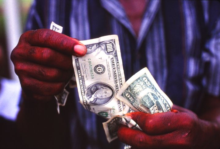 Man holding money to bet at a horse race