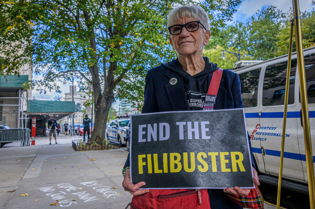 Participant seen holding a sign at the protest. Fair...