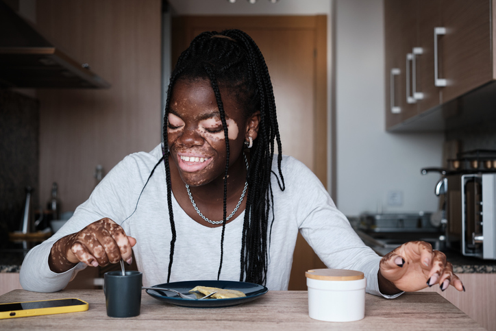 Happy black woman having healthy breakfast in kitchen