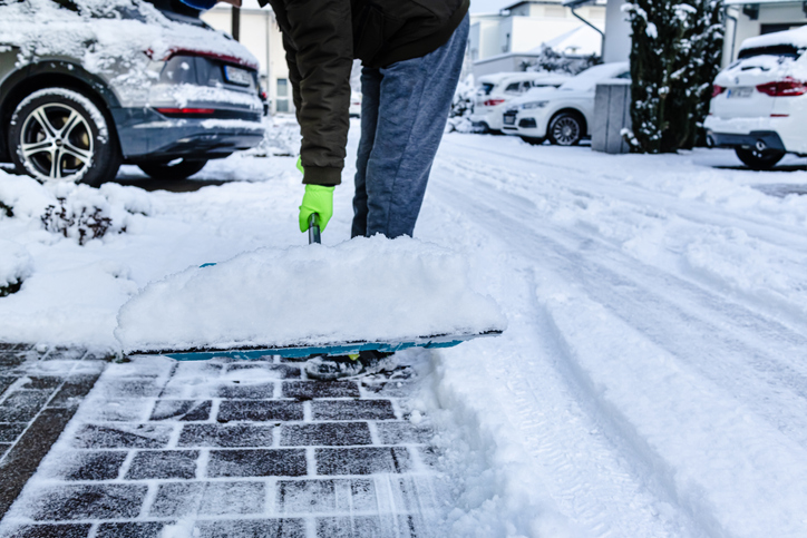 Teenager shoveling snow outdoors on winter day