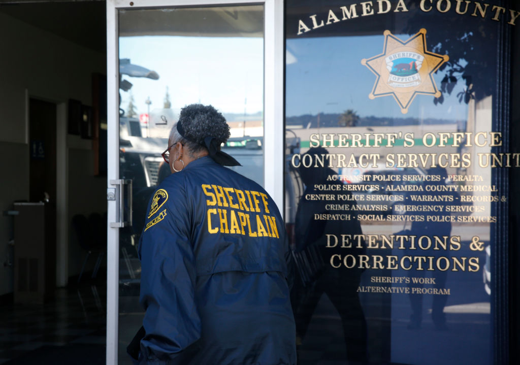 A department chaplain arrives to assist friends and family members waiting to hear of loved ones at an Alameda County Sheriff's office in Oakland, Calif. on Saturday, Dec. 3, 2016 after at least nine people died in an overnight fire