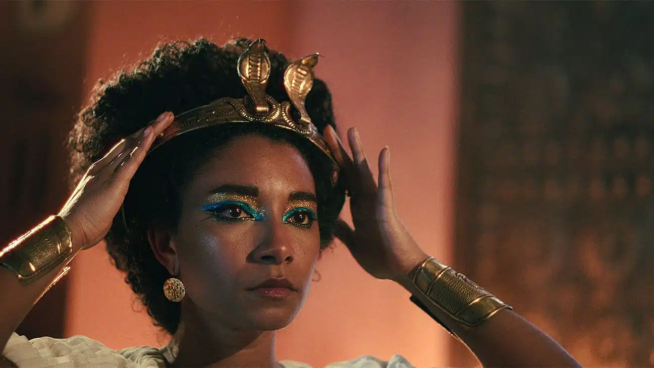 Cleopatra (Adele James) adjusts her crown in the Netflix docuseries Queen Cleopatra