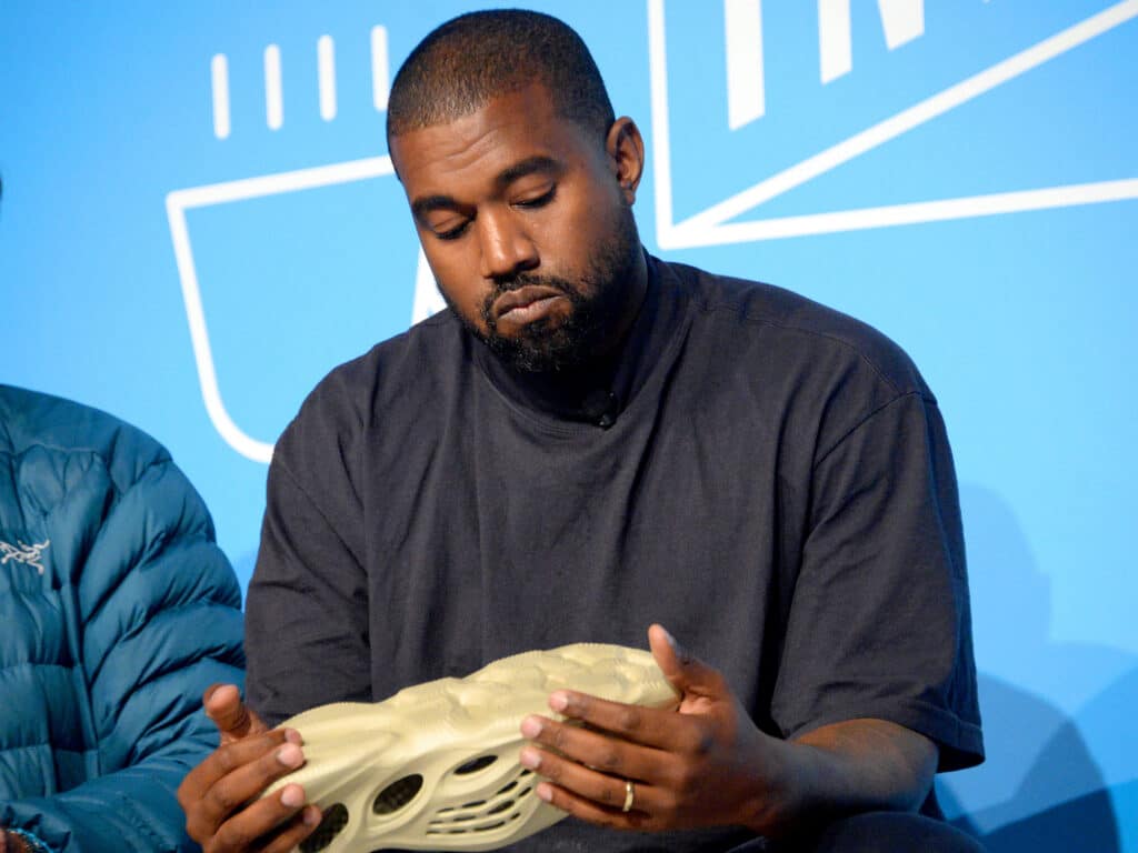 Kanye West holds a Yeezy shoe