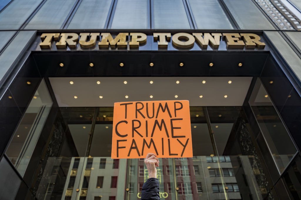 Participant seen holding a sign outside Trump Tower. In...