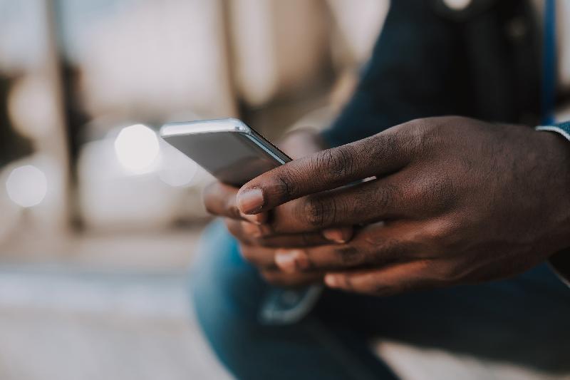 Black Man's Hands using Smartphone (Adobe Stock)